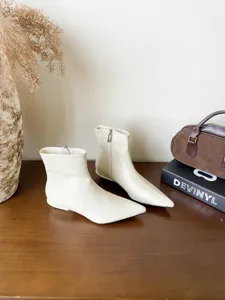Bottines chics à bout pointu et petit talon en blanc cassé, idéales pour la mode d'automne.