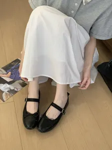 Vue détaillée d'élégantes chaussures Mary Jane plates noires avec nœud et bride, style français.