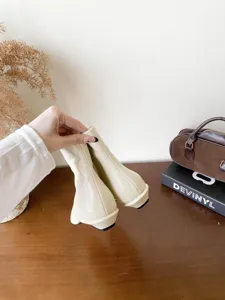 Vue détaillée d'élégantes bottines beiges françaises à bout pointu et talon carré élégant.