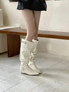 Vista detallada de botas elegantes con puntera cuadrada y tacón plano de moda chic.