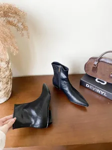 Vue détaillée de bottines noires à talons bas et bout pointu, style français chic.