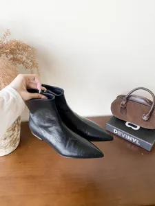 Gros plan de bottines noires à bout pointu, mettant en valeur le cuir et une silhouette élégante.