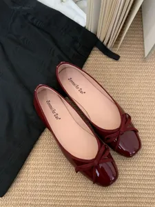 Burgundy patent leather flat ballet shoes with a sweet square toe and delicate bow knot detail.