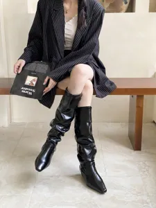 Botas altas negras elegantes con tacon bajo y puntera cuadrada para mujeres de moda.