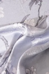 Detailed view of blue floral silk scarf fabric showing soft drape and elegant texture closeup