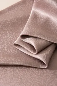 Close-up detail of luxurious mulberry silk scarf fabric, showing soft folds and unique texture.