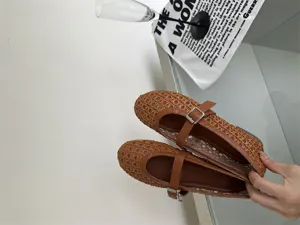 Vista dettagliata di scarpe Mary Jane marroni intrecciate, design traforato con fibbia.