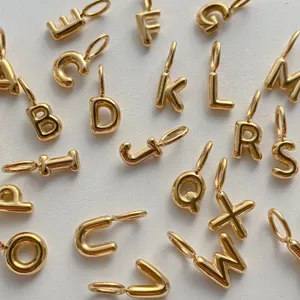 Dettaglio di ciondoli lettere alfabeto 3D gonfie oro, accessorio per gioielli in metallo.