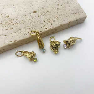 Nahaufnahme von goldenen Blumen Anhängern mit bunten Zirkoniasteinen für DIY Schmuckdesign.