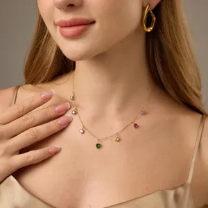 Goudkleurige ketting met kleurrijke edelsteenbedels en bijpassende oorbellen, detailopname.