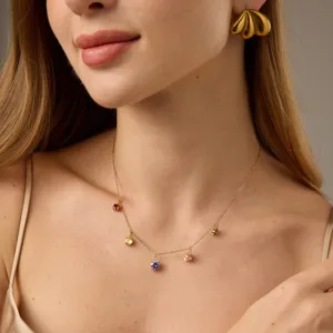 Detailopname van een delicate vergulde ketting met kleurrijke zirconia hangers en fijne schakels.