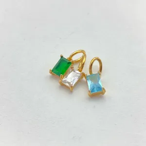 Detailed close-up of geometric square zircon pendants, gold-plated stainless steel charms.
