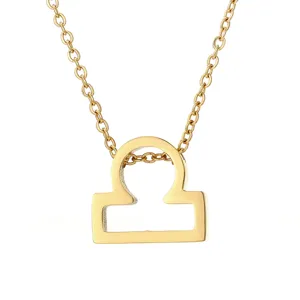 Gros plan détaillé du collier pendentif signe astrologique Balance doré, texture métal.