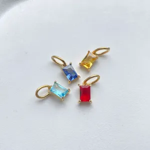 Detail shot of four colorful rectangular baguette zirconia DIY gold plated pendants.