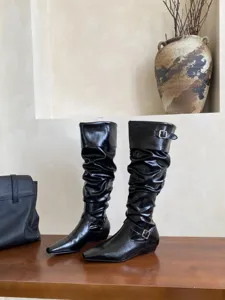 Elegantes botas altas negras con punta cuadrada y tacón plano bajo para mujeres.