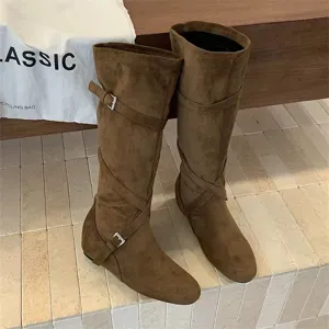 Vintage brown suede knee-high fashion boots with cross straps and metal buckles for women.