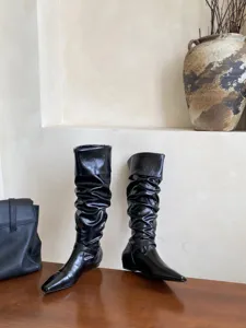 Botas altas holgadas negras con puntera cuadrada pequeña y tacón plano para mujer.