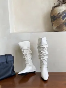 Vista detallada de elegantes botas slouchy blancas crema con puntera cuadrada y tacom bajo.
