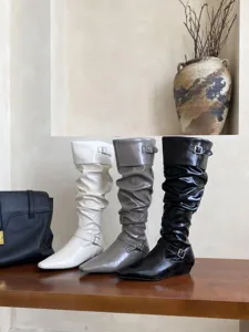 Vista detallada de botas slouchy con punta cuadrada, tacón plano bajo y hebilla lateral.