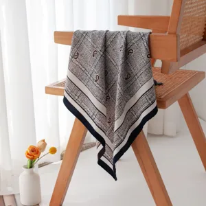Detailed view of the luxury silk wool paisley square scarf, elegant geometric pattern drape.
