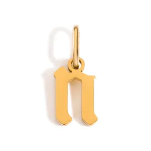 Dettaglio di un ciondolo con lettera gotica dorata, elegante ciondolo iniziale per collane e bracciali.