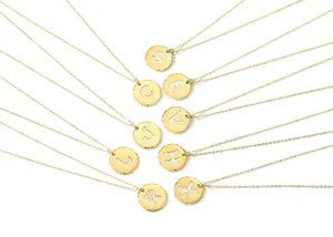 Gold stainless steel round alphabet initial pendant necklace with white enamel background.