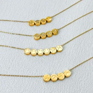 Gold stainless steel charm necklace with engraved cylindrical beads and cute symbols.