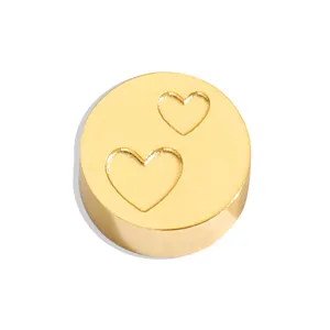 Close-up detail of a gold stainless steel round DIY charm bead with engraved double heart design.