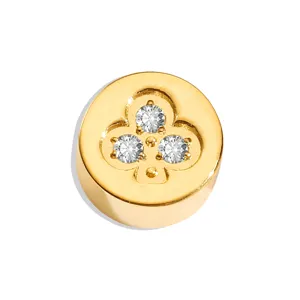 Detailed macro shot of gold stainless steel round bead featuring clover stone design.