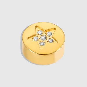 Close-up detail of a golden round DIY charm bead featuring a sparkling rhinestone star.