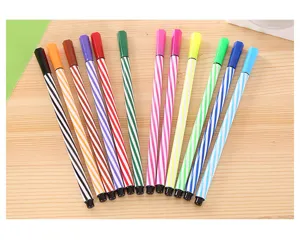 Gros plan de douze stylos rayés colorés disposés proprement sur une surface de bureau.