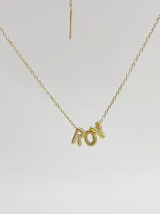 Close-up detail of a gold 3D bubble letter pendant necklace showing exquisite craftsmanship.