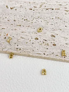 Close-up of retro 3D bubble gold letter beads, perfect for DIY jewelry making and pendants.