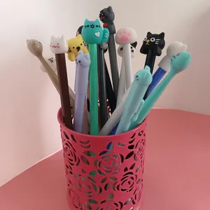 Primo piano dettagliato di simpatiche penne gel con gatto in un portapenne rosa.