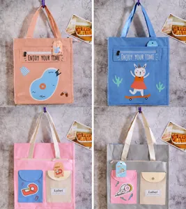 Dettagli della borsa di tela con simpatici motivi di cartoni animati e tasche anteriori.