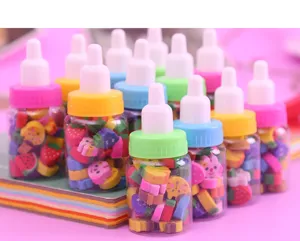 Vue détaillée de mini gommes mignonnes en forme de fruits dans des biberons transparents.