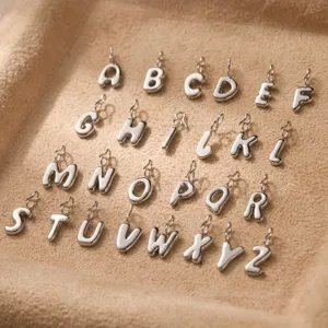 Dettaglio ciondoli lettere 3D in acciaio inossidabile, charm alfabeto per gioielli.