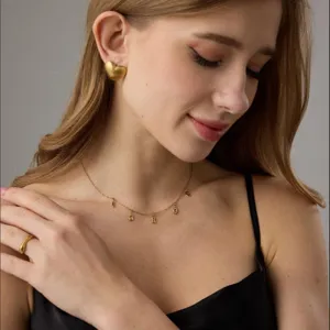 Set di gioielli in acciaio inossidabile dorato con orecchini a cuore e collana con lettere.