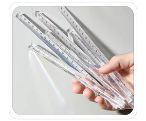 Détail de règle d'échelle triangulaire transparente avec des graduations précises.