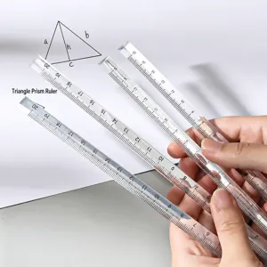 Détail de règle triangulaire transparente avec graduations claires pour le dessin géométrique.