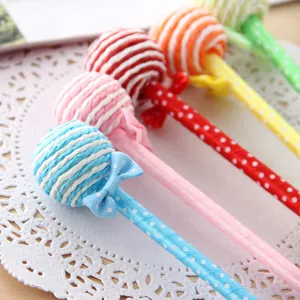 Close-up detail of cute lollipop ballpoint pens with polka dot ribbons and bowknot design.