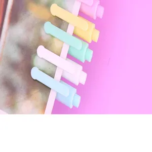 Close-up detail of pastel gel pens clipped on card, featuring cute colorful stationery design.