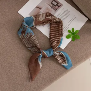 Detailed view of the blue and brown printed scarf, elegant pattern and soft fabric texture.