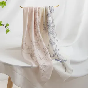 Detailed close-up view of lightweight printed cashmere scarf draped on elegant gold stand.