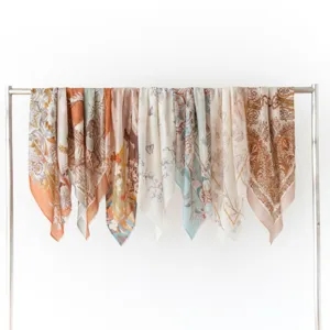 Detailed view of lightweight printed silk square scarves featuring elegant vintage floral patterns.