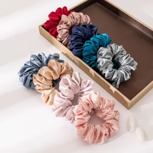 Close-up detail of multi-color satin silk hair scrunchies, soft smooth texture and vibrant.
