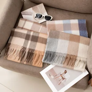 Detail view of stylish minimalist plaid cashmere winter scarf with cozy Maillard tones and fringe.