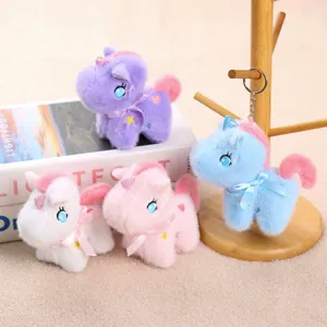 Primer plano de lindos llaveros de peluche de unicornio en diseños coloridos con lazos suaves.
