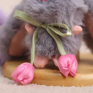 Dettaglio pendente coniglietto peluche grigio, nastro verde e decorazione con tulipano rosa.