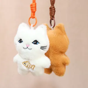Close-up of cute plush cat keychain with embroidered fish detail and colorful hanging strap.